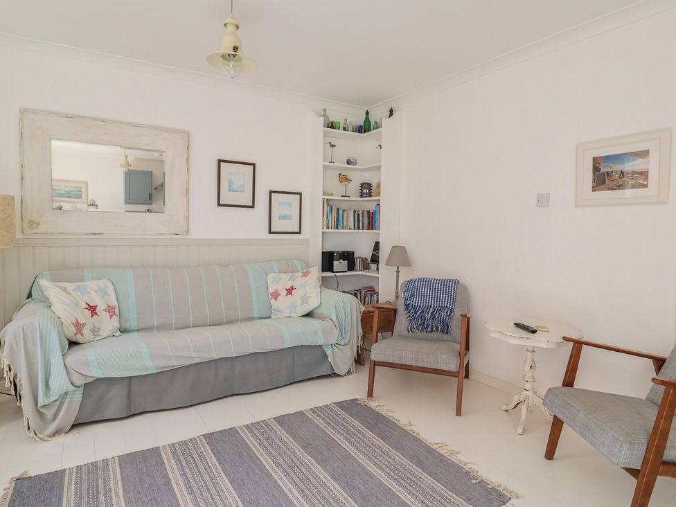 A living room with a sofa and armchair at 1 Bay View Court in Lyme Regis