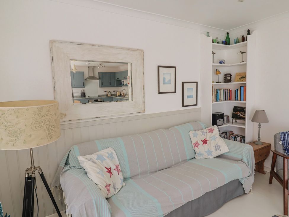 A living room with a sofa and bookshelf at 1 Bay View Court Lyme Regis