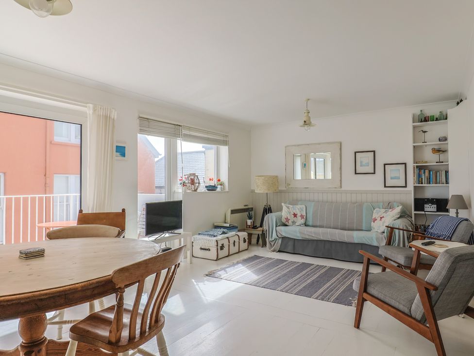 A living room with a dining table and sofa at 1 Bay View Court in Lyme Regis