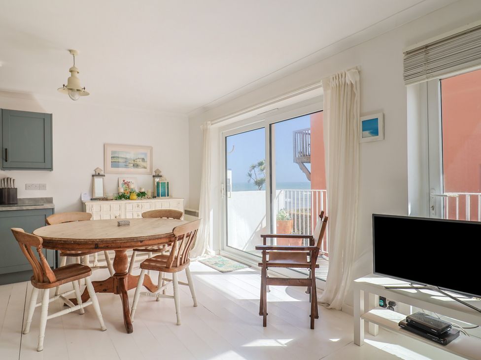 A dining room with a table and chairs at 1 Bay View Court in Lyme Regis