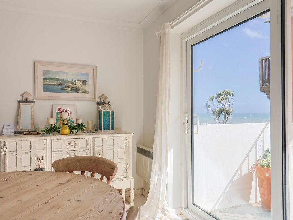 A dining room with a sideboard and a view of the sea at 1 Bay View Court in Lyme Regis