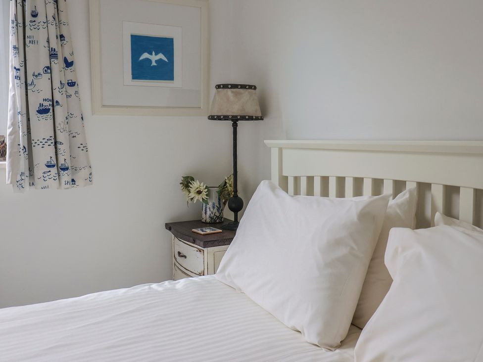 A bedroom with a bed and lamp at 1 Bay View Court in Lyme Regis