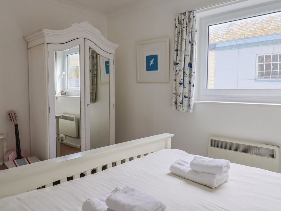 A bedroom with a bed and wardrobe at 1 Bay View Court in Lyme Regis