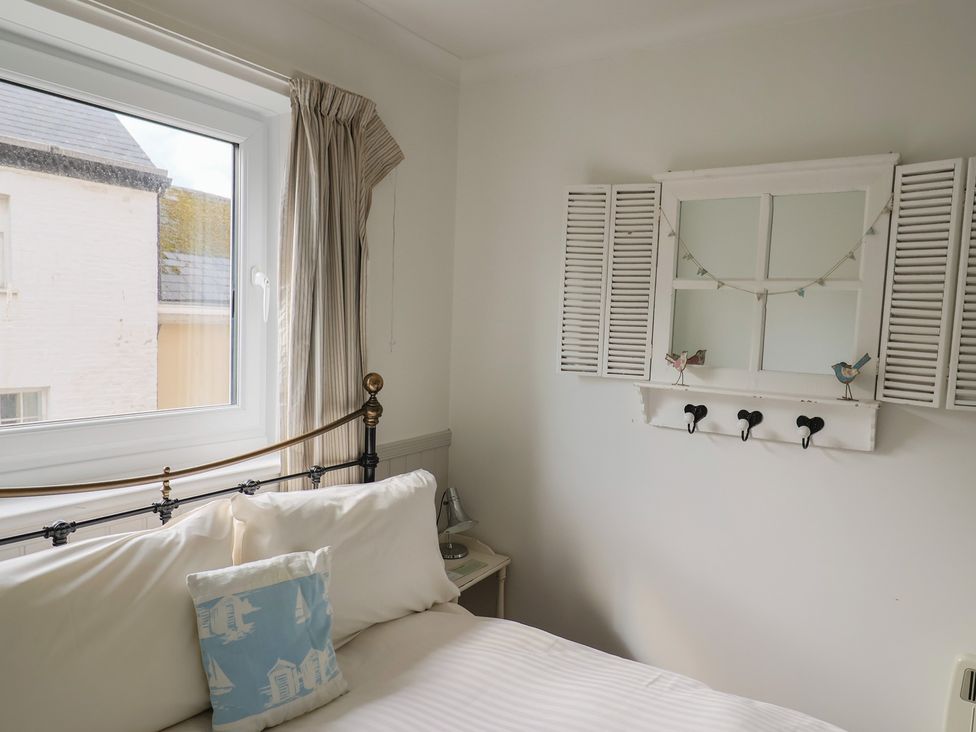 A bedroom with a bed and window at 1 Bay View Court in Lyme Regis