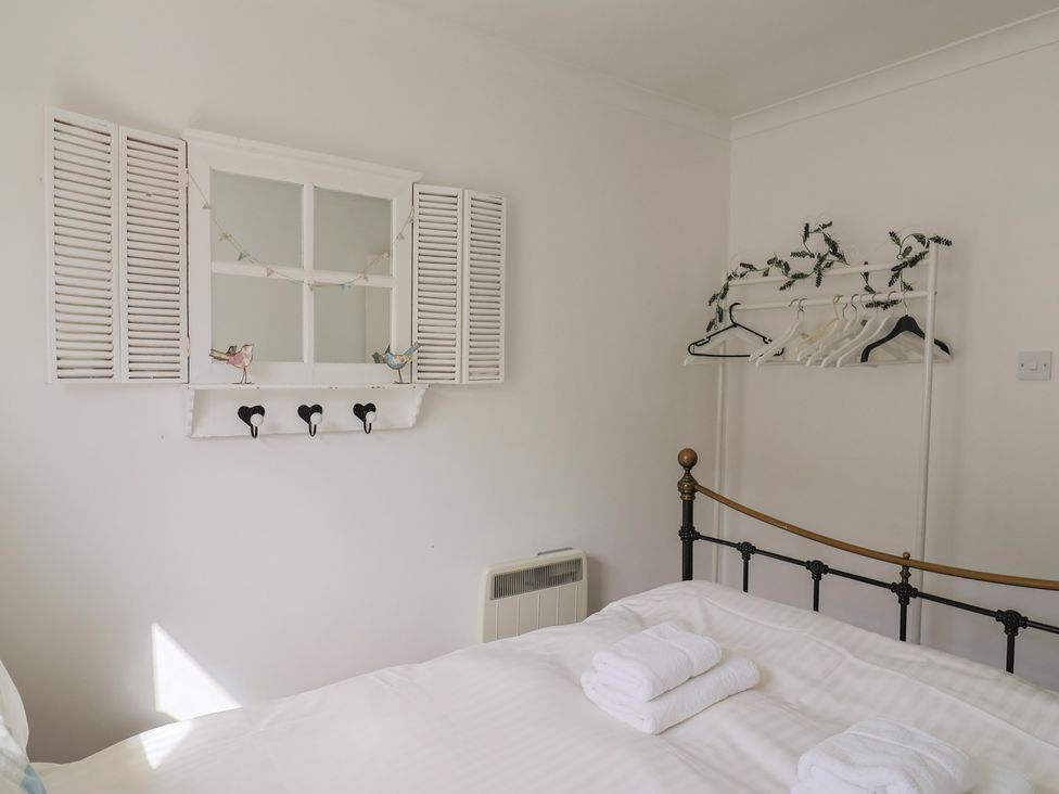 A bedroom with a bed and towels at 1 Bay View Court in Lyme Regis