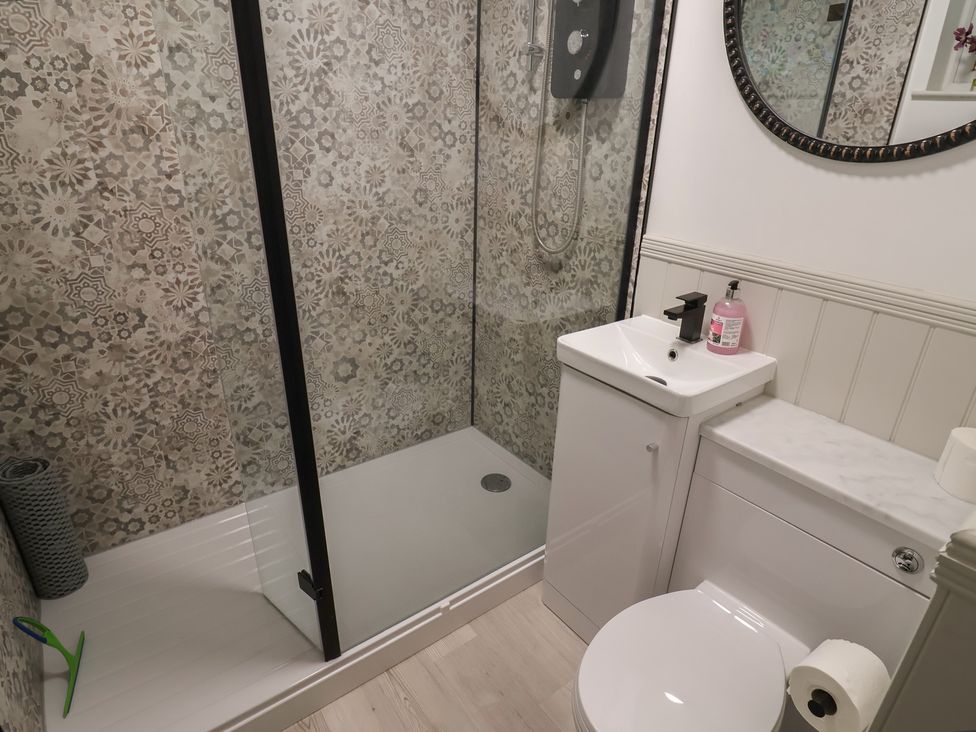 A bathroom with a shower, sink, and toilet at 1 Bay View Court in Lyme Regis