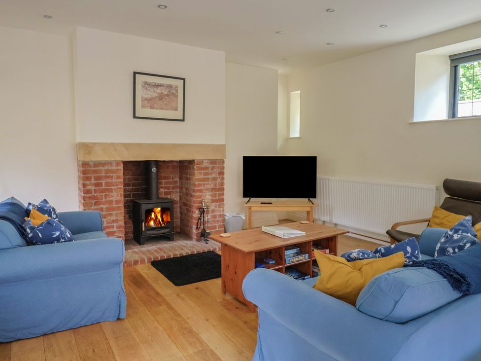 A living room with a sofa and television at Yard Cottage in Rousdon