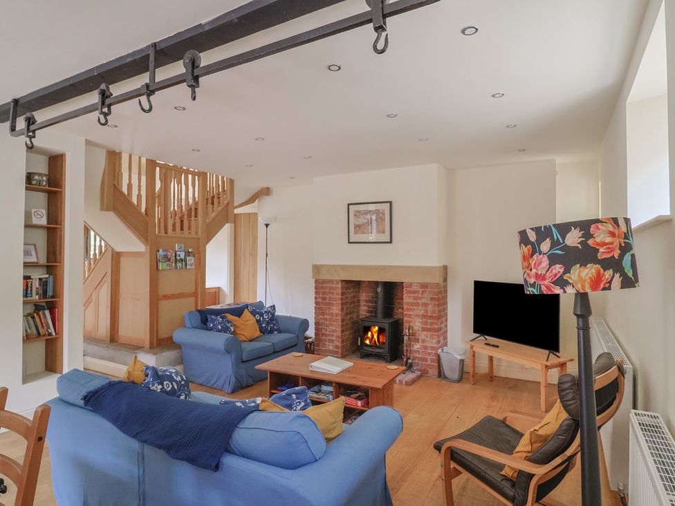 A living room with a fireplace and sofa at Yard Cottage in Rousdon