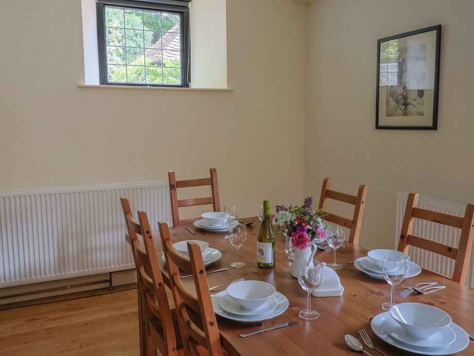 A dining room with a table set for a meal at Yard Cottage in Rousdon