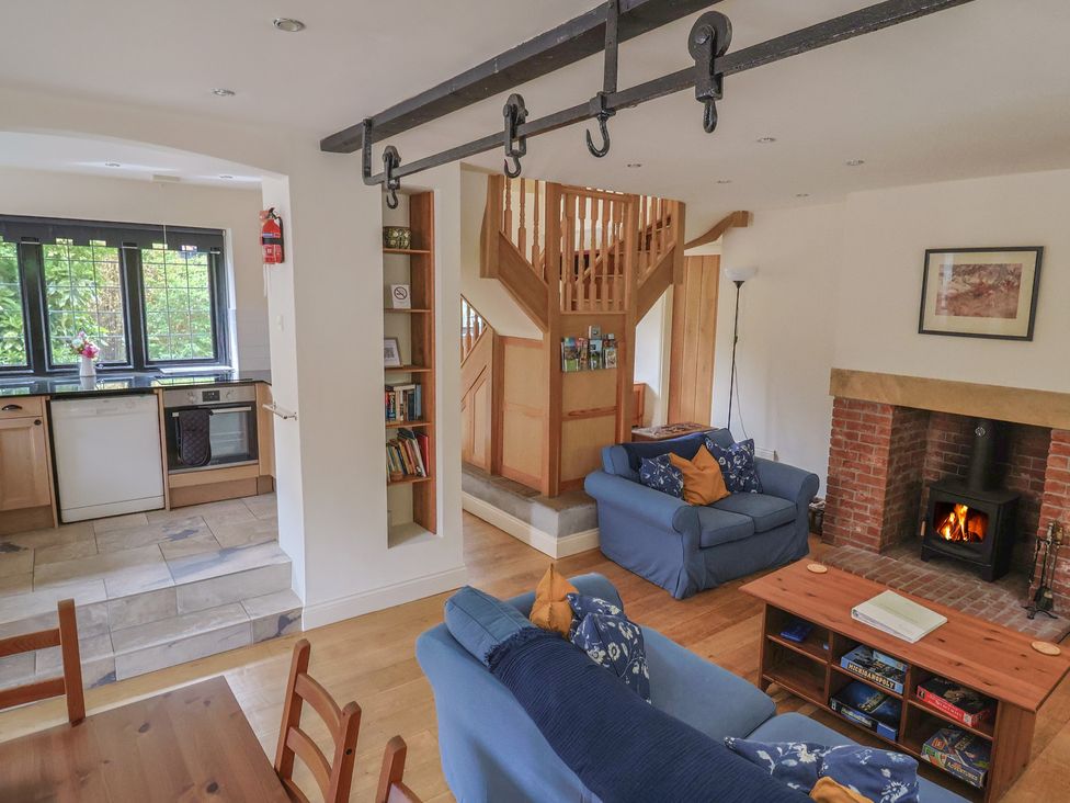 A living room with a fireplace and sofa at Yard Cottage in Rousdon