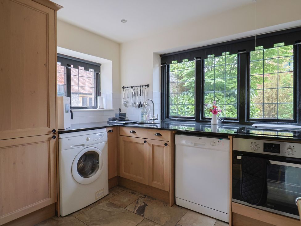 A kitchen with appliances and windows at Yard Cottage in Rousdon