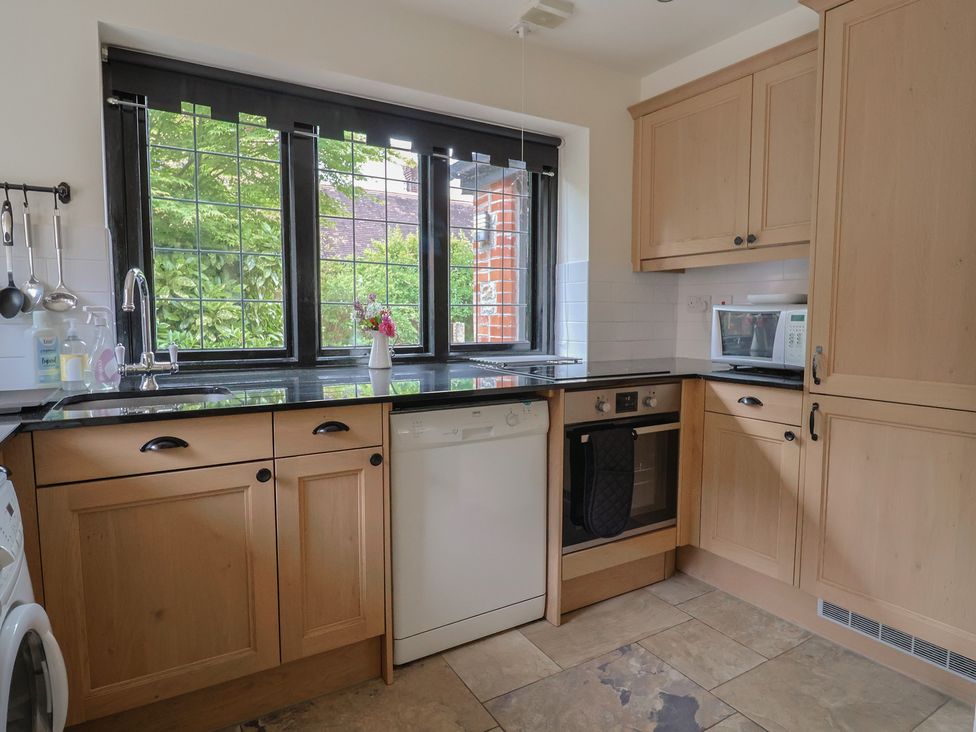 A kitchen with cabinets, sink, dishwasher, oven, and microwave at Yard Cottage in Rousdon