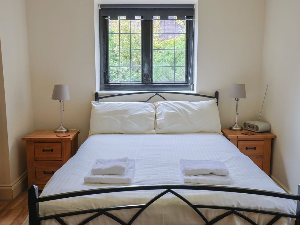 A bedroom with a bed and nightstands at Yard Cottage Rousdon