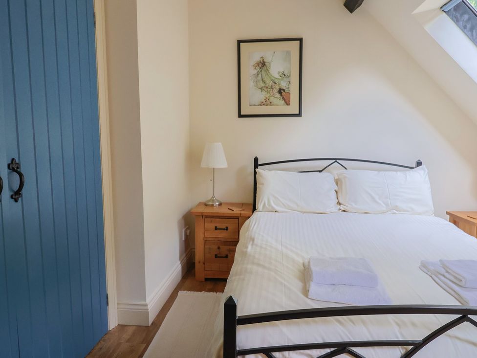 A bedroom with a bed and bedside tables at Yard Cottage in Rousdon
