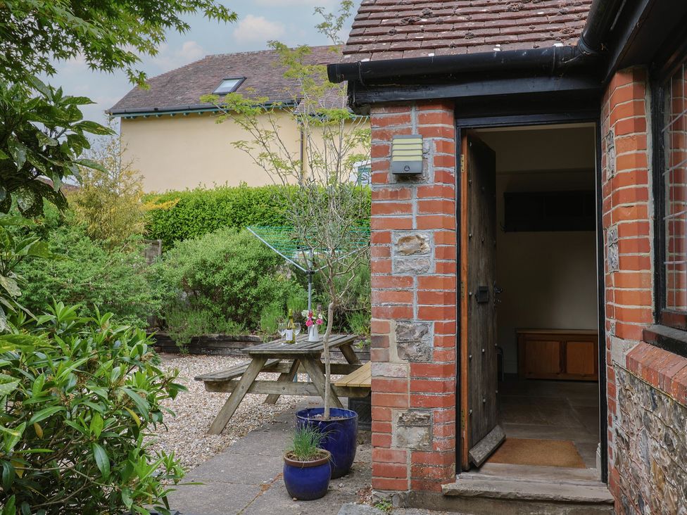 A garden with a table and chairs at Yard Cottage in Rousdon