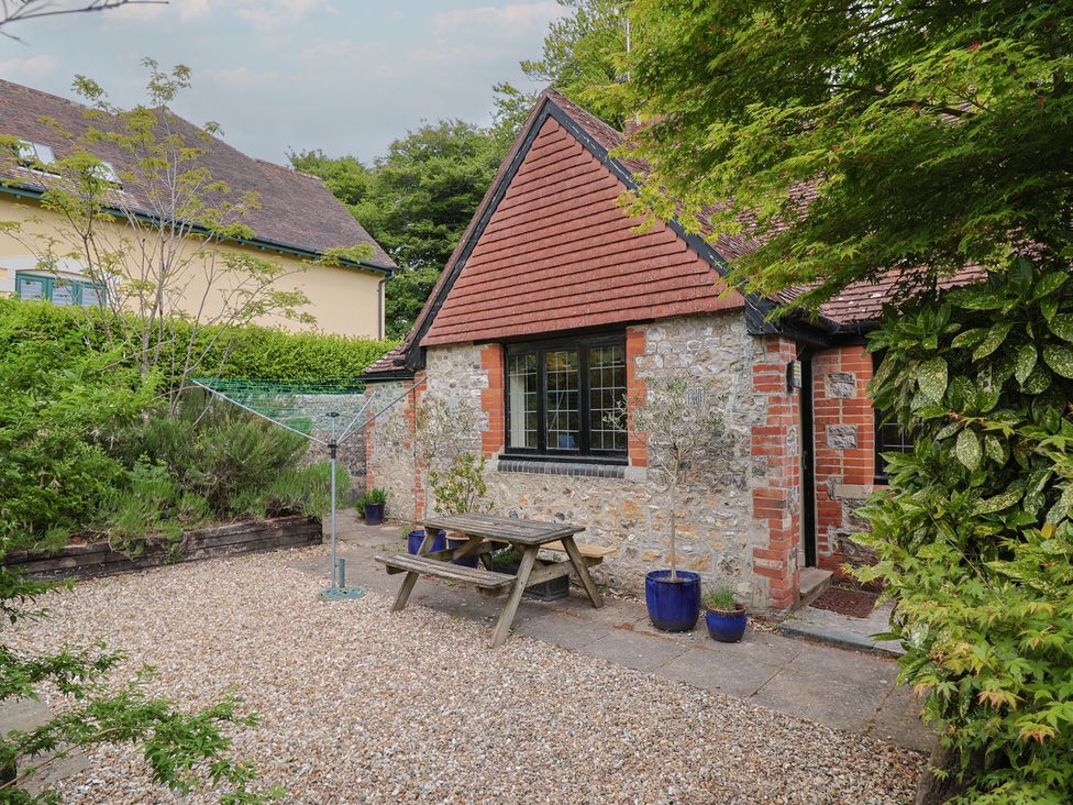 A garden with a table and chairs at Yard Cottage in Rousdon