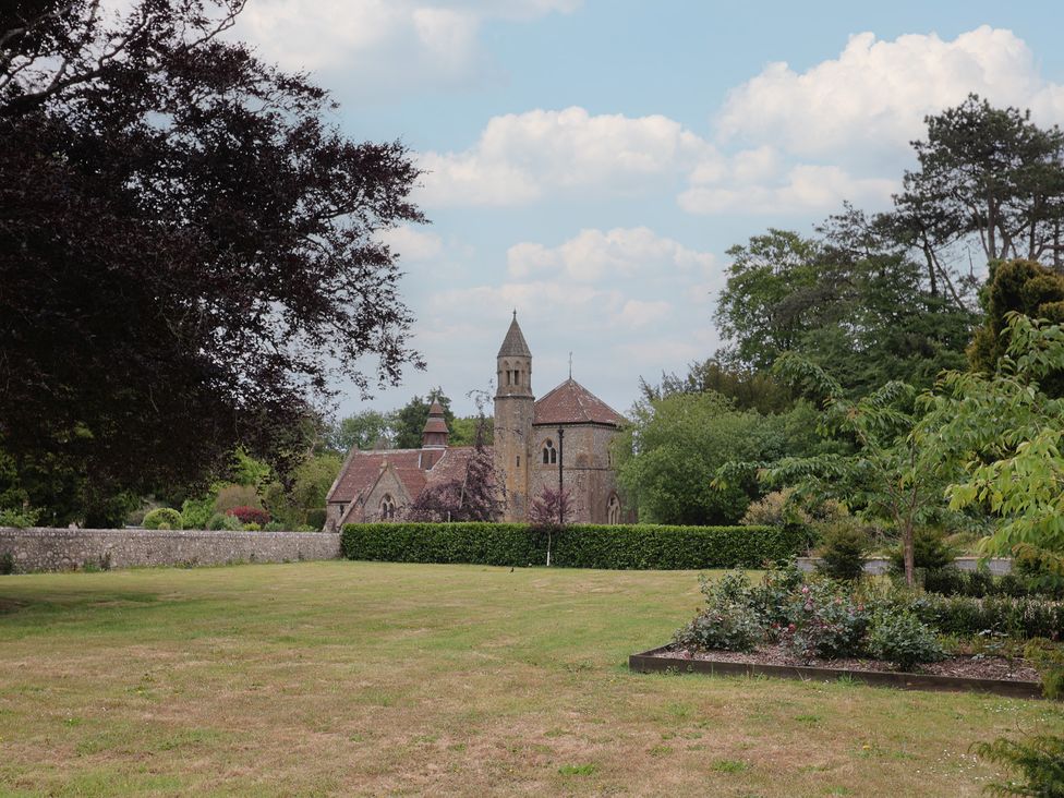 A building with a tower and greenery at Yard Cottage in Rousdon