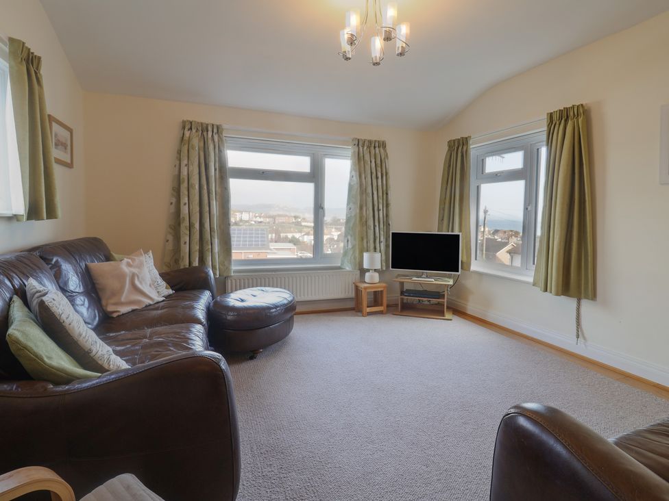A living room with a sofa and television at Greystones in Lyme Regis