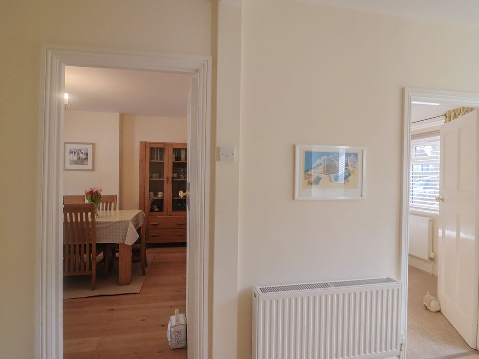 A hallway with a view into a dining room at Greystones Lyme Regis