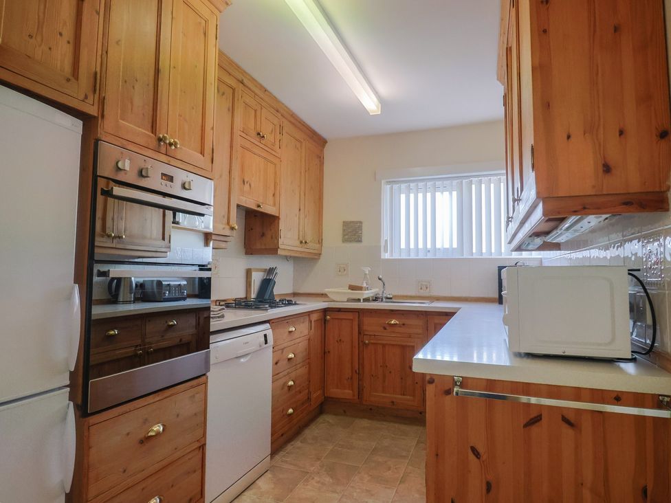 A kitchen with wooden cabinetry and appliances at Greystones Lyme Regis