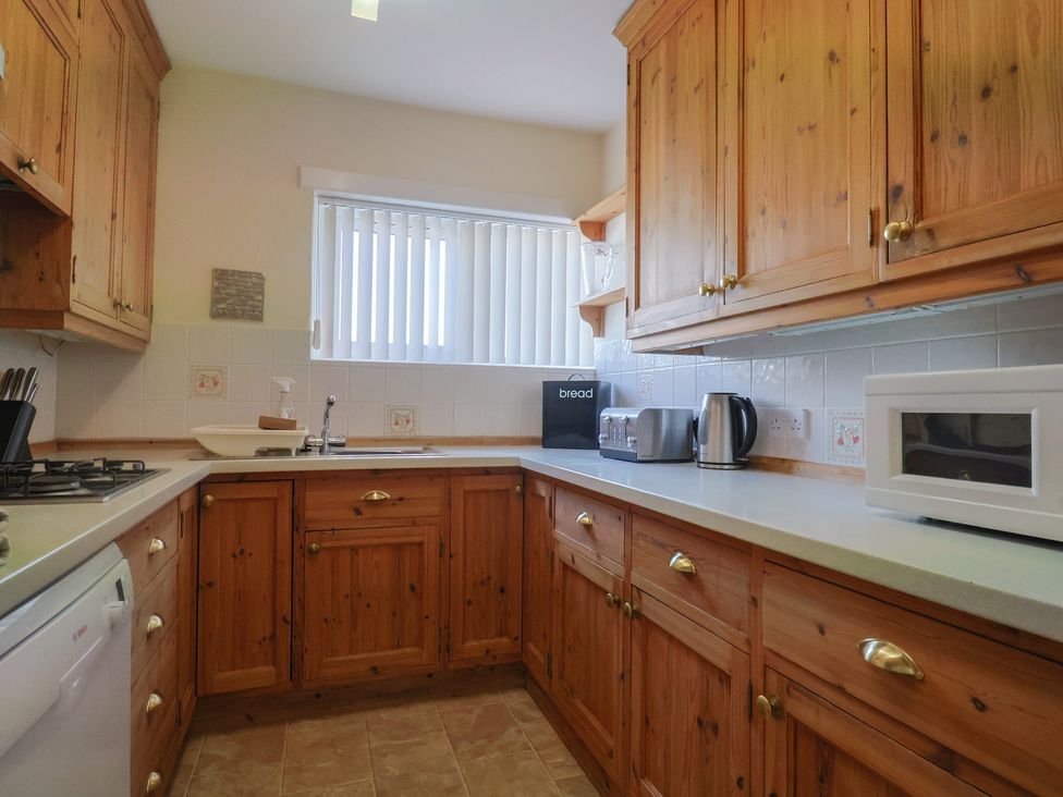 A kitchen with wooden cupboards and appliances at Greystones in Lyme Regis