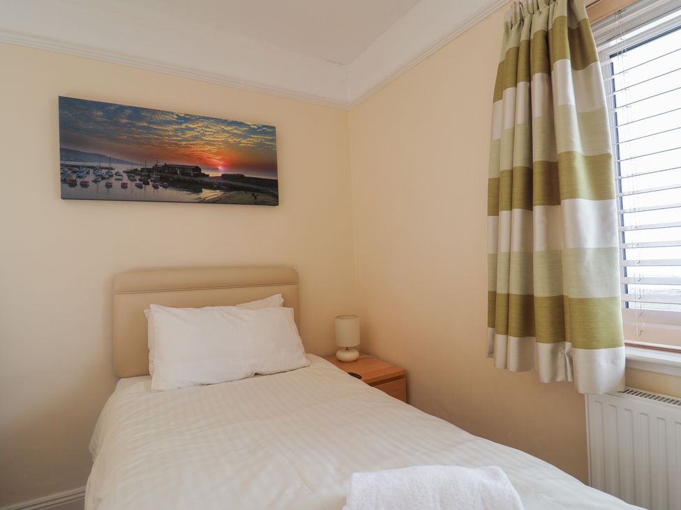 A bedroom with a bed and a painting at Greystones in Lyme Regis