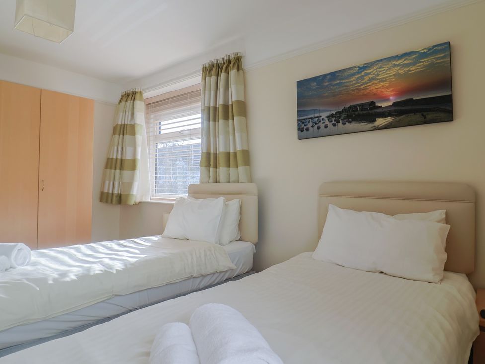 A bedroom with two beds and a window at Greystones in Lyme Regis