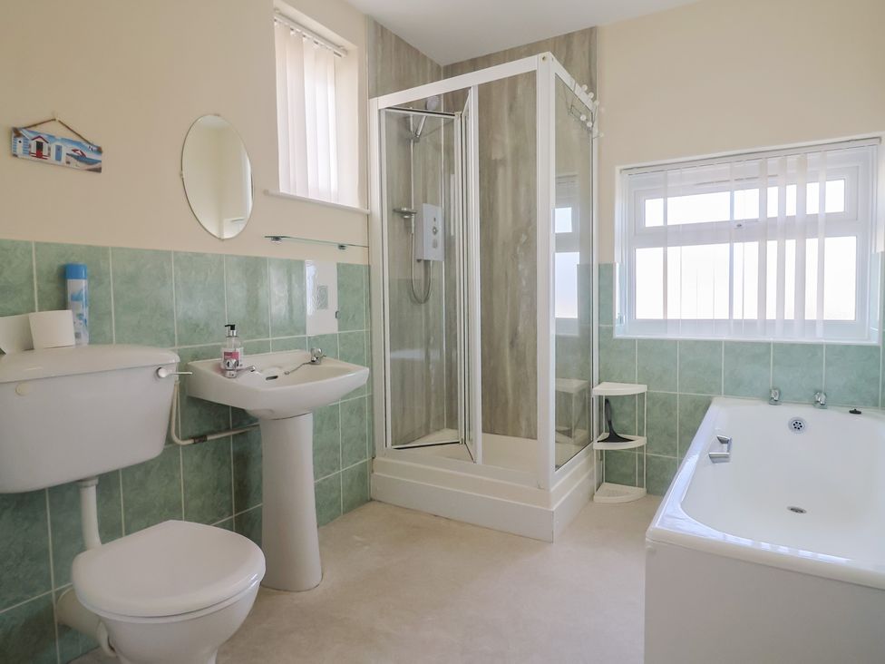 A bathroom with shower, bathtub, toilet and sink at Greystones Lyme Regis