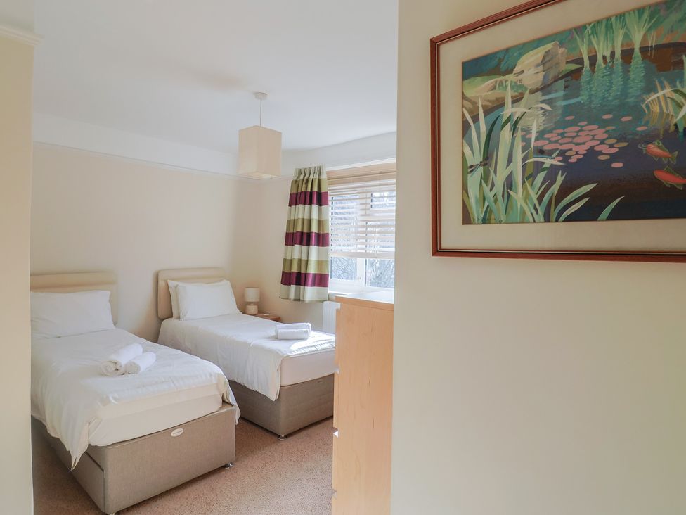 A bedroom with twin beds and a painting at Greystones in Lyme Regis