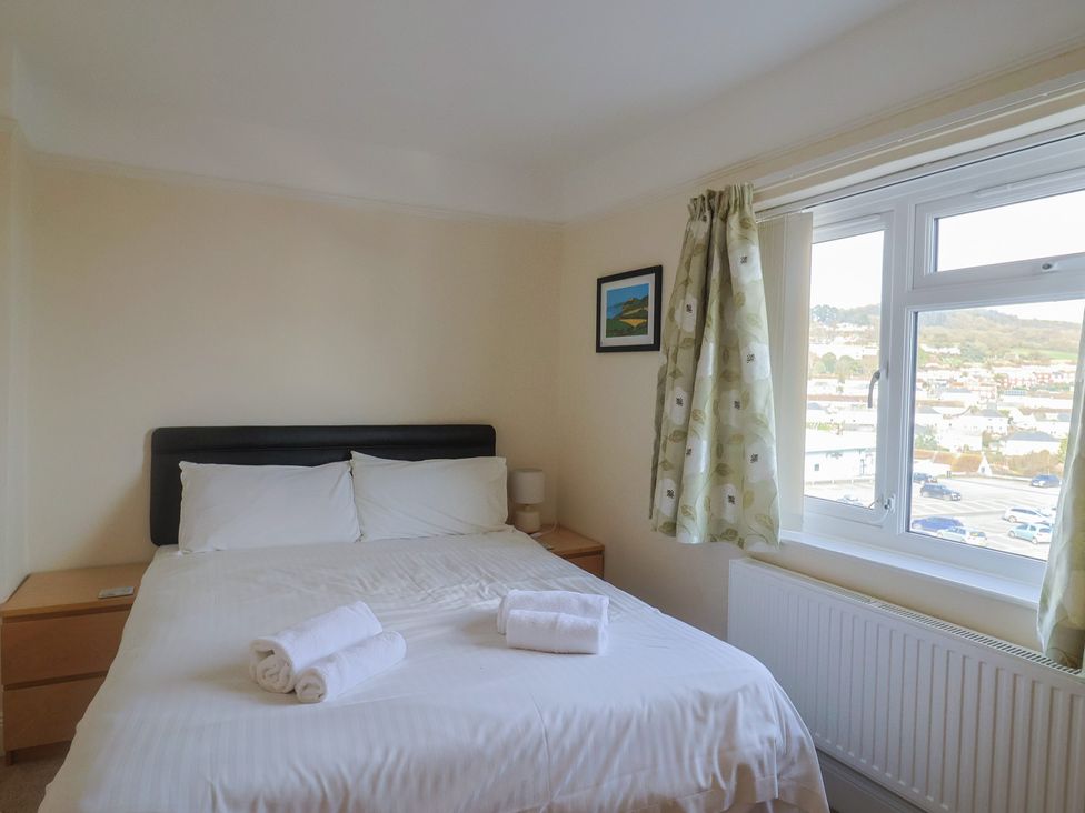 A bedroom with a bed and window at Greystones Lyme Regis