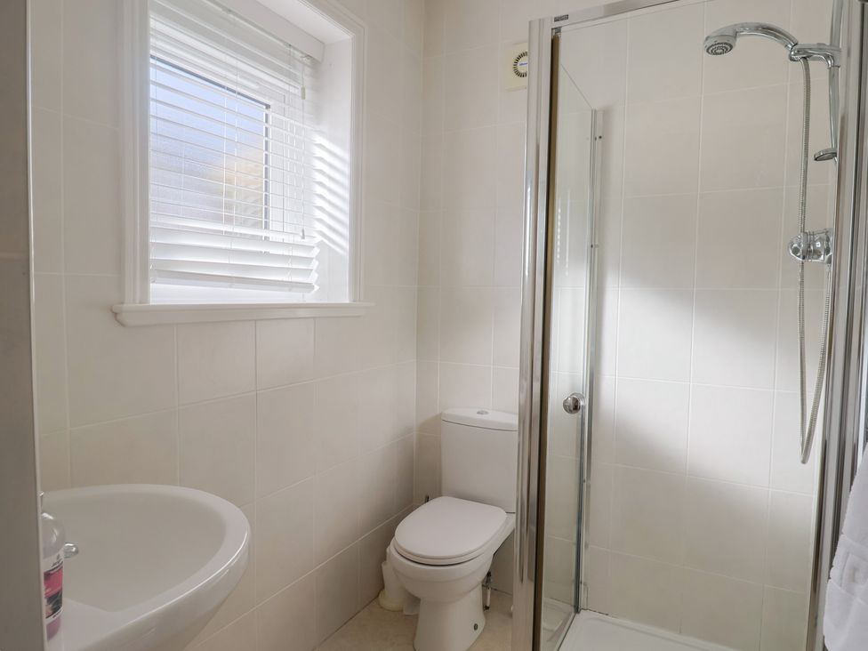 A bathroom with a sink toilet and shower at Greystones Lyme Regis
