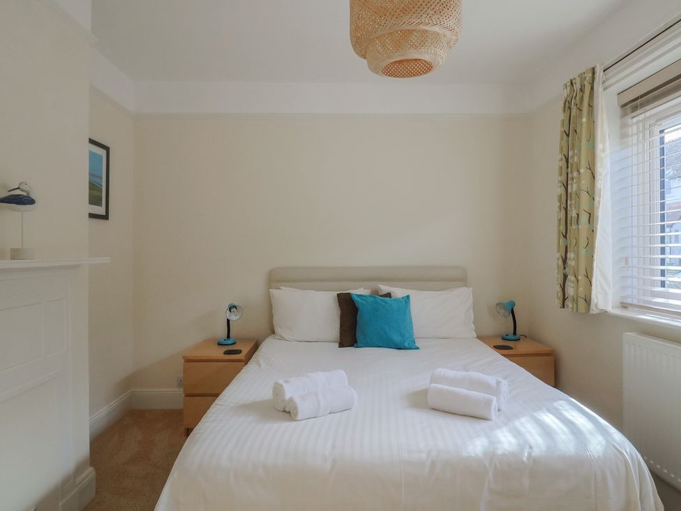 A bedroom with a bed and bedside tables at Greystones Lyme Regis