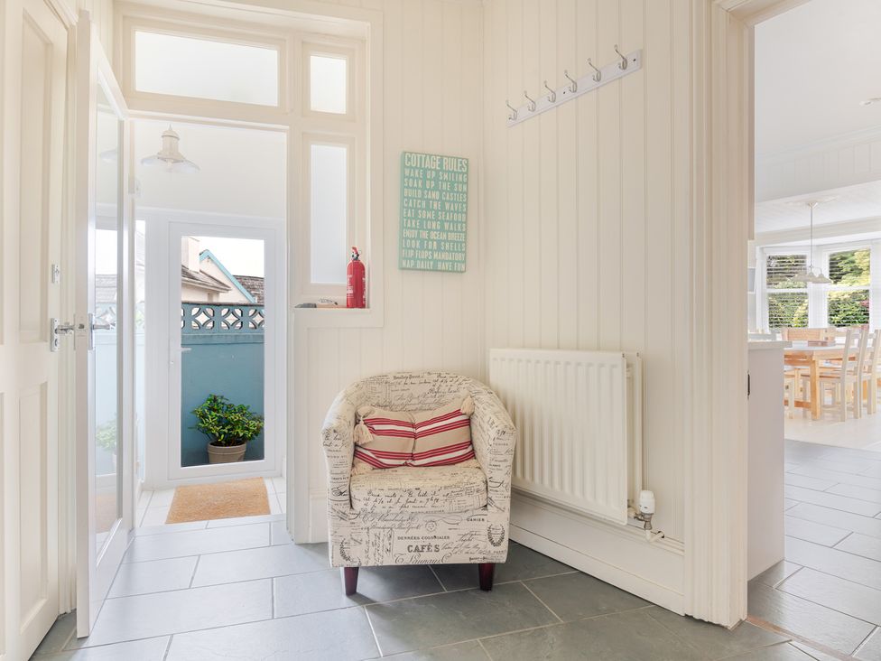 A hallway with a chair and hooks at 2 Hadleigh Villas in Lyme Regis