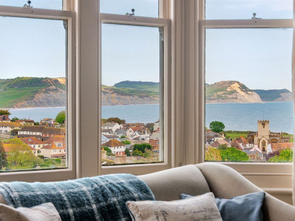 A living room with a view of the coastline and town at 2 Hadleigh Villas Lyme Regis