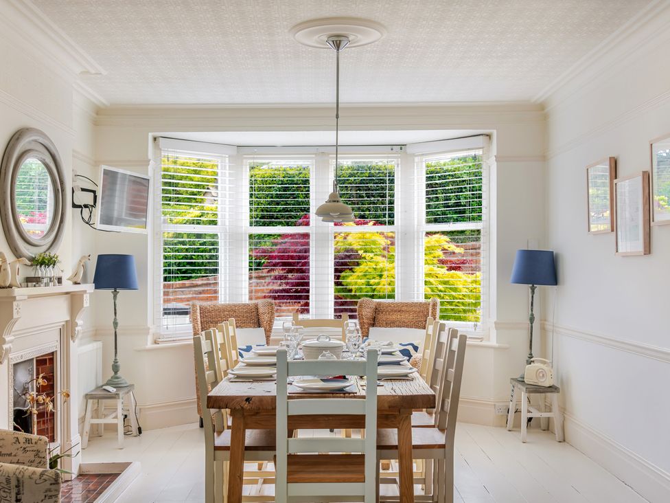 A dining room with a wooden table and chairs at 2 Hadleigh Villas Lyme Regis