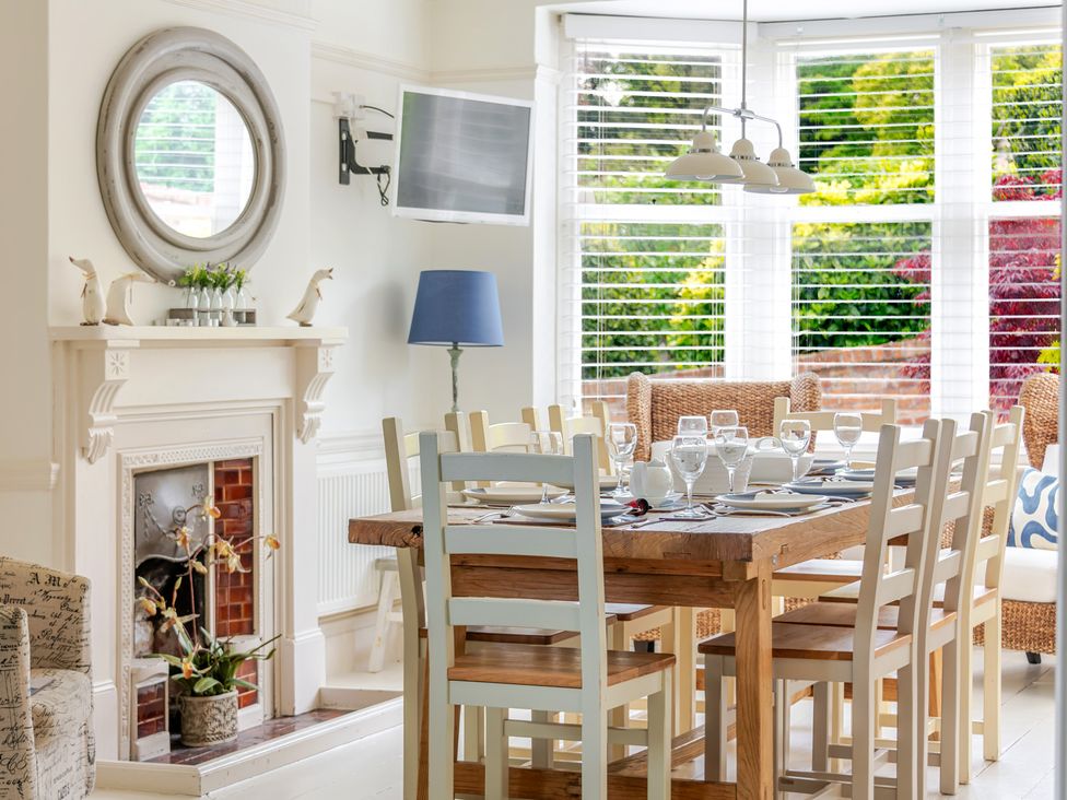 A dining room with a table set for meals at 2 Hadleigh Villas Lyme Regis