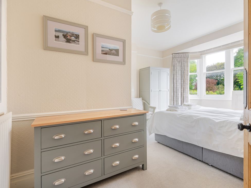 A bedroom with a dresser, bed and wardrobe at 2 Hadleigh Villas in Lyme Regis