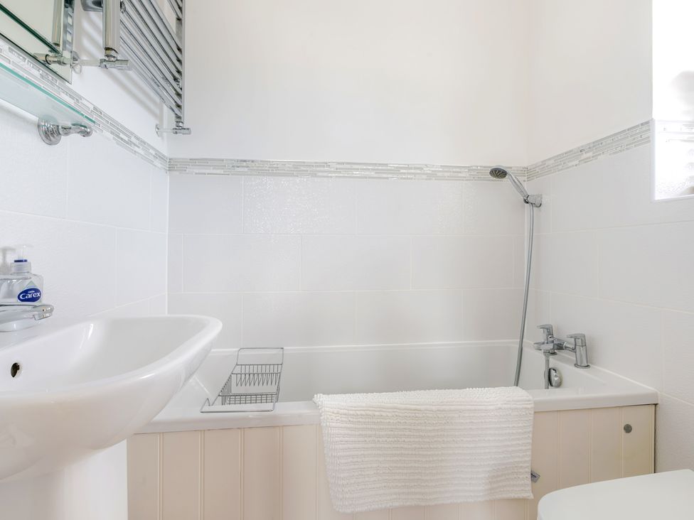 A bathroom with a bathtub and sink at 2 Hadleigh Villas Lyme Regis