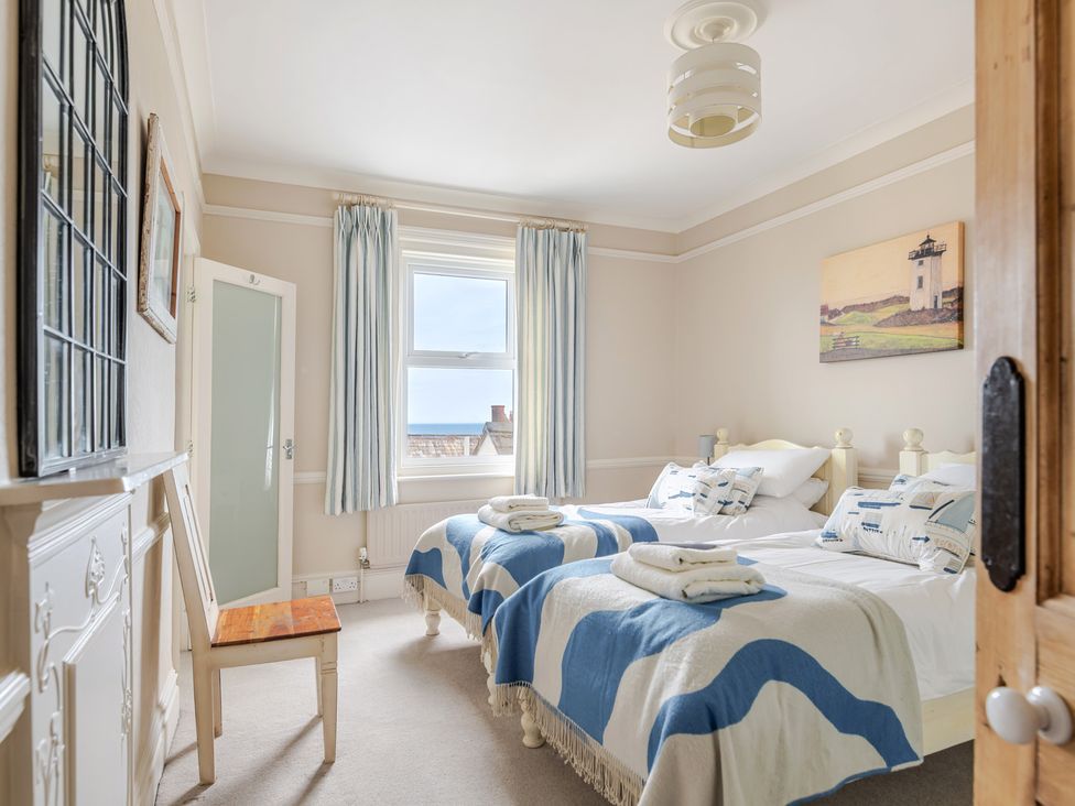 A bedroom with two beds and a window at 2 Hadleigh Villas in Lyme Regis