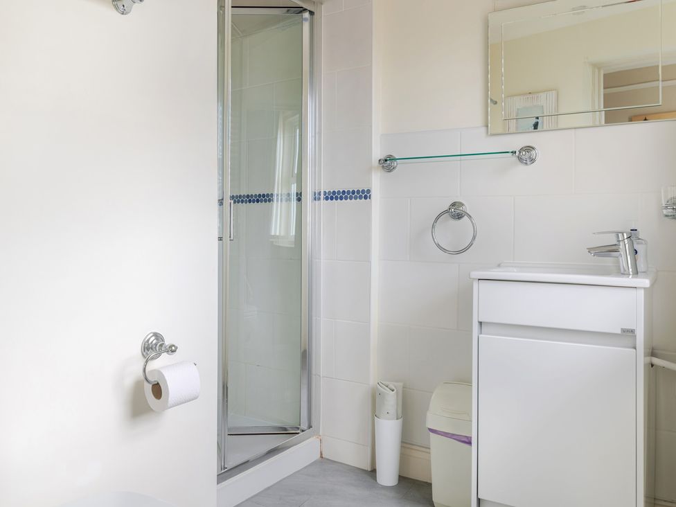A bathroom with a shower, toilet, and vanity unit at 2 Hadleigh Villas Lyme Regis