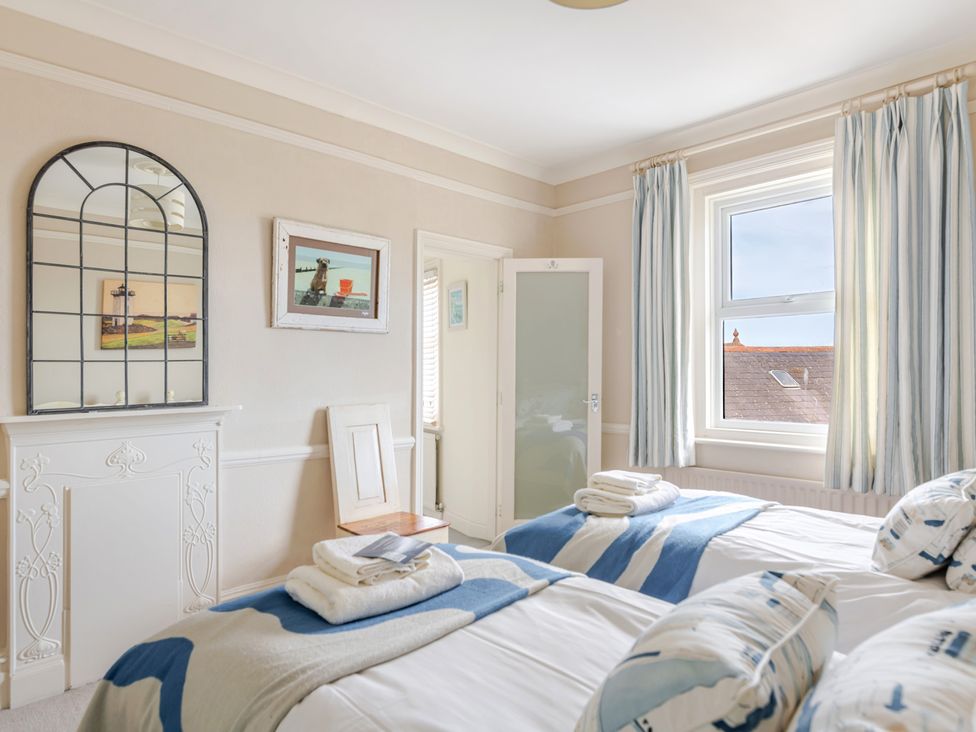 A bedroom with two beds and a mirror at 2 Hadleigh Villas in Lyme Regis