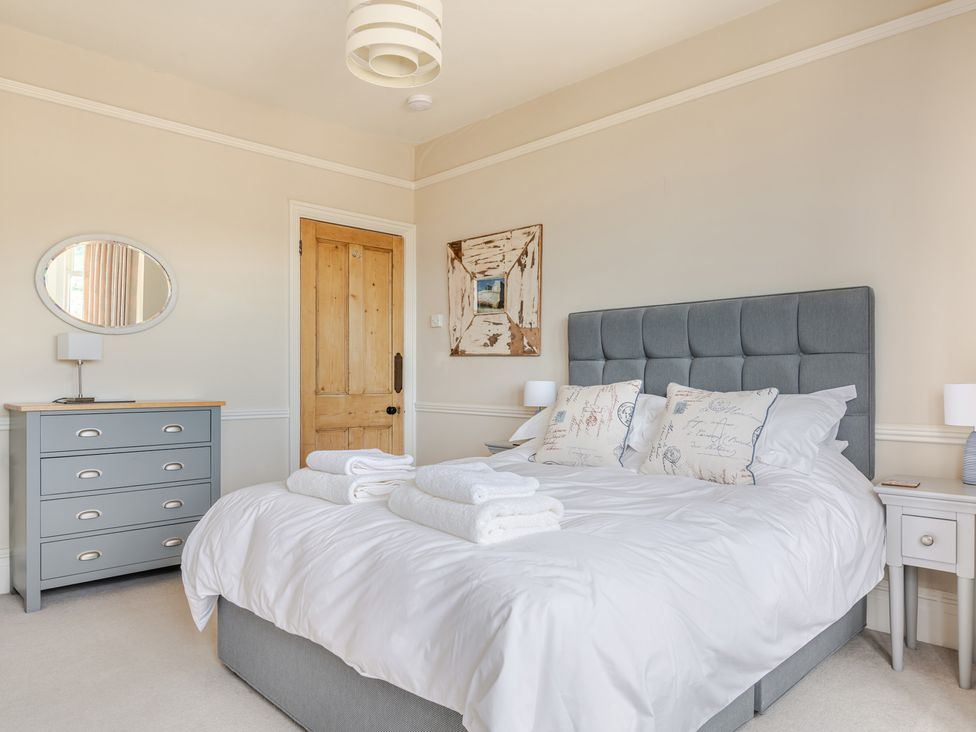 A bedroom with a bed and dresser at 2 Hadleigh Villas in Lyme Regis