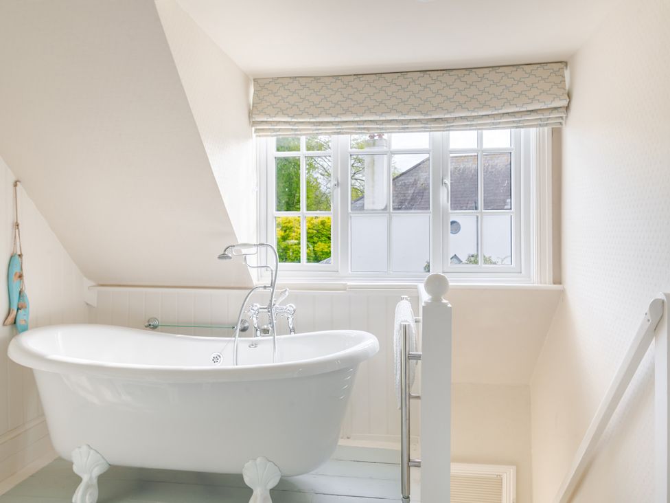 A bathroom with a bathtub and window at 2 Hadleigh Villas in Lyme Regis