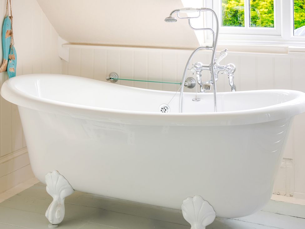 A bathroom with a bathtub and faucet at 2 Hadleigh Villas Lyme Regis