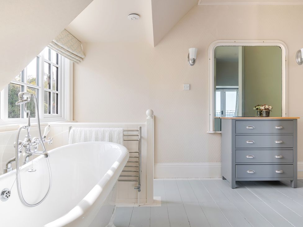 A bathroom with a bathtub and dressing table at 2 Hadleigh Villas in Lyme Regis