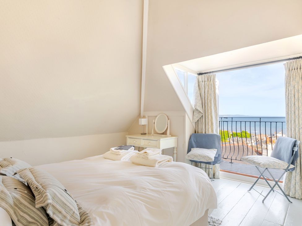 A bedroom with a window opening to a view at 2 Hadleigh Villas Lyme Regis