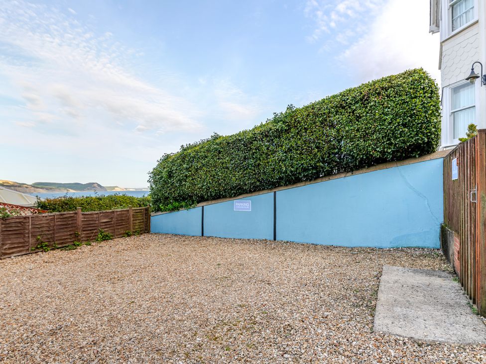 A parking area with gravel surface and greenery at 2 Hadleigh Villas in Lyme Regis
