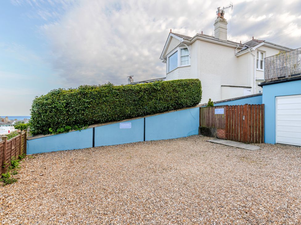 An outdoor parking area with gravel and a hedge at 2 Hadleigh Villas in Lyme Regis
