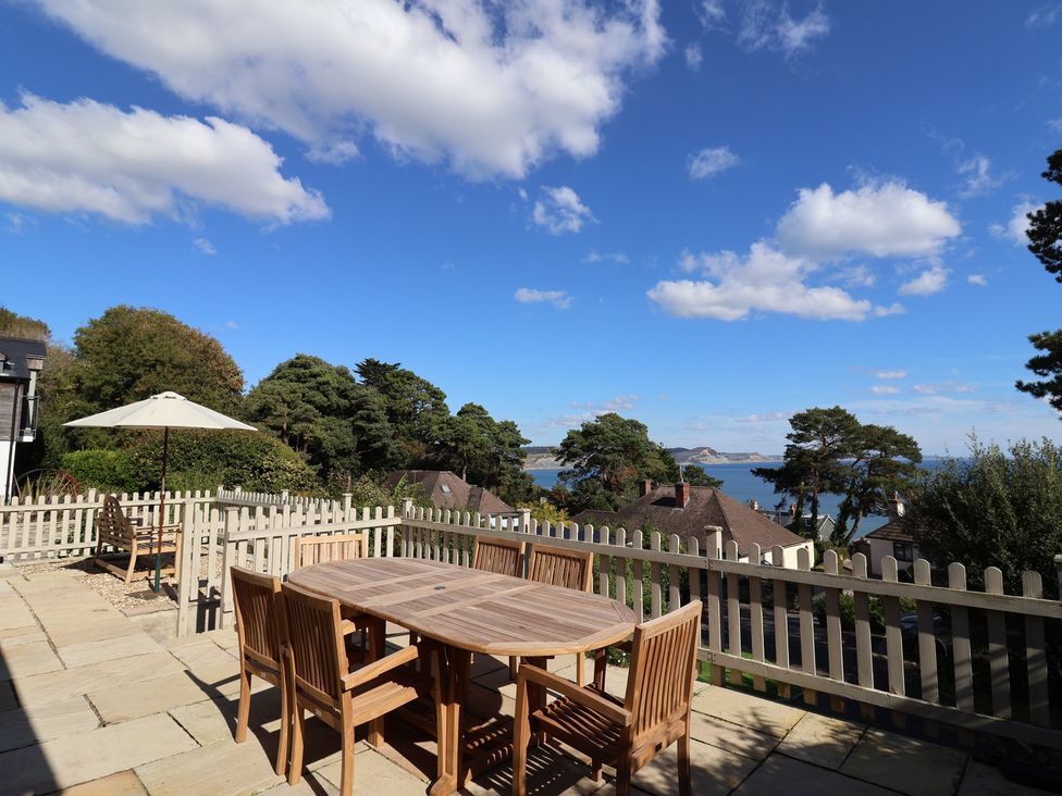 An outdoor terrace with a table and chairs at Westhaven in Lyme Regis