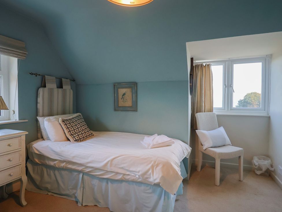 A bedroom with a bed and a chair at Westhaven in Lyme Regis